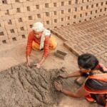 Dwie Indianki ręcznie formują cegły z gliny na zewnątrz