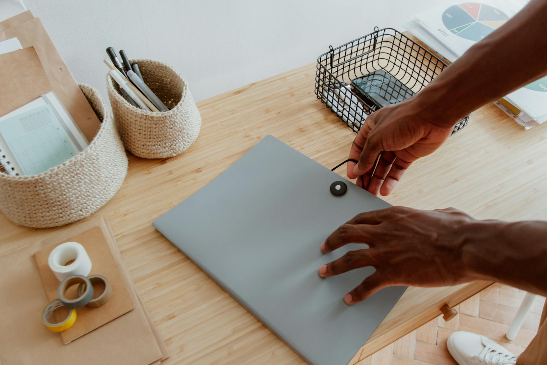 Ręce porządkujące dokumenty i akcesoria na biurku w domowym biurze