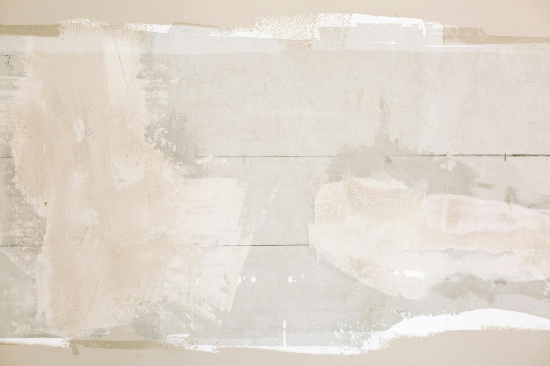 Zbliżenie na niepomalowaną ścianę z widoczną gładzią i warstwą farby