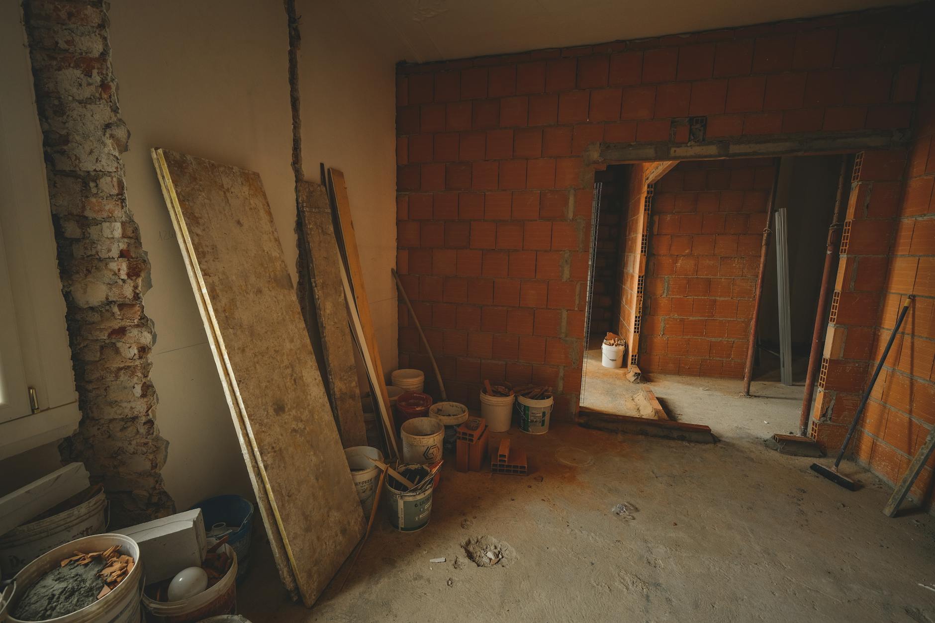 Ceglana ściana w trakcie przeróbek instalacji, narzędzia porozrzucane