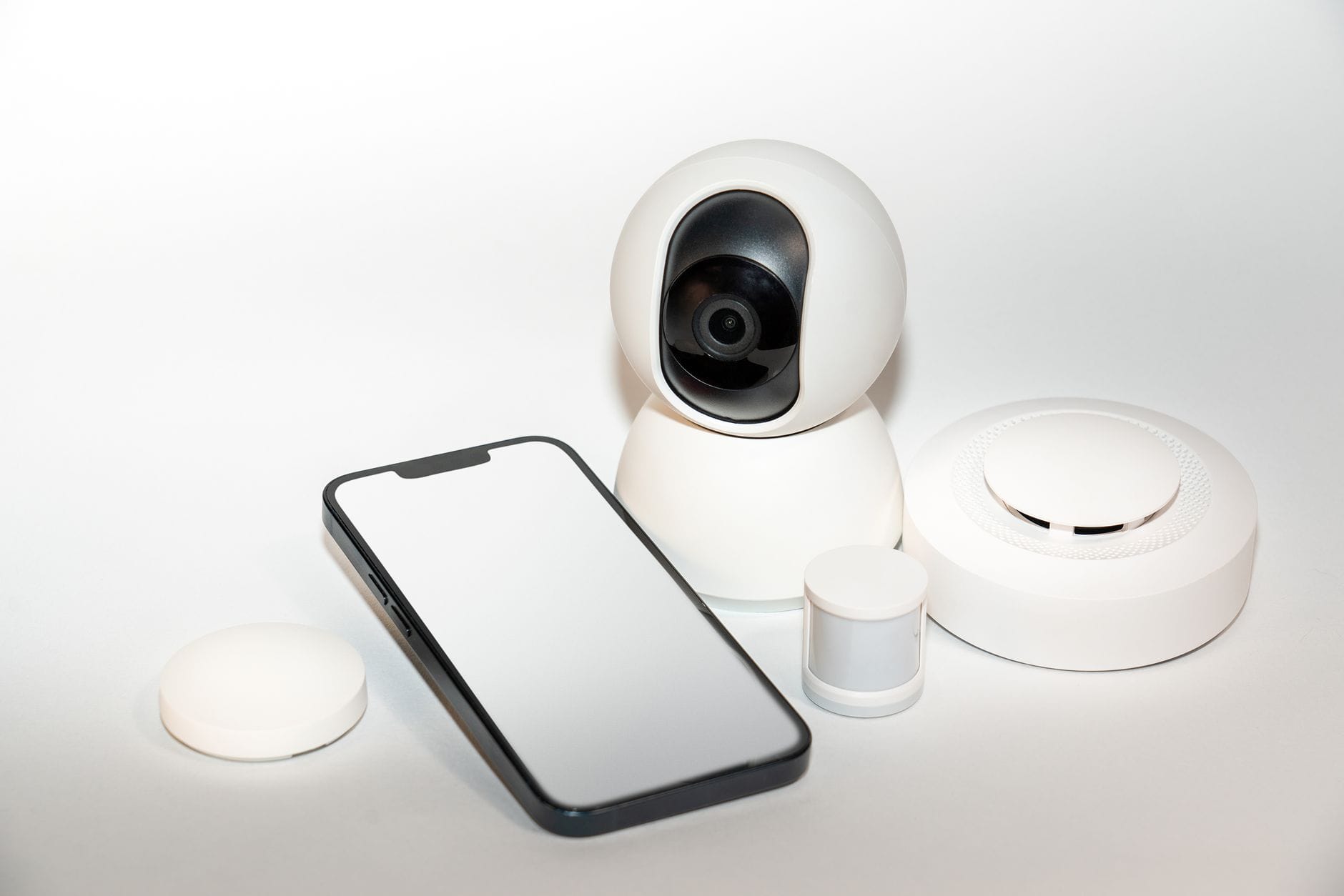 Zestaw urządzeń smart home i smartfon z podglądem zabezpieczeń